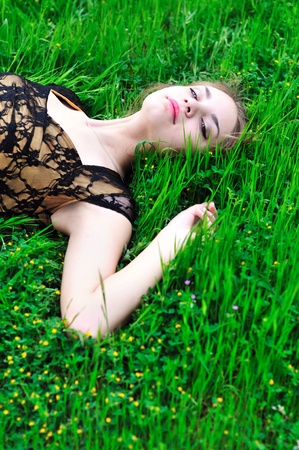 resting teen pretty girl laying on the spring grassの写真素材