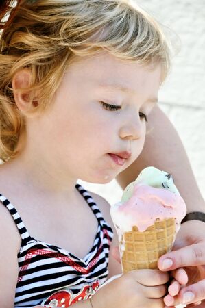 little girl eating sweet ice creamの写真素材