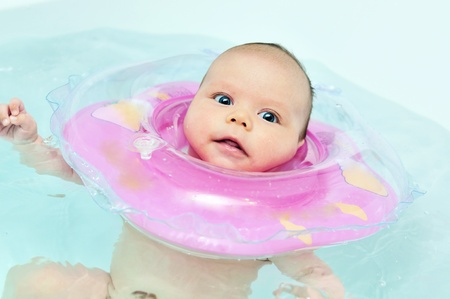 swimming two monthes old baby with neck swim ringの写真素材