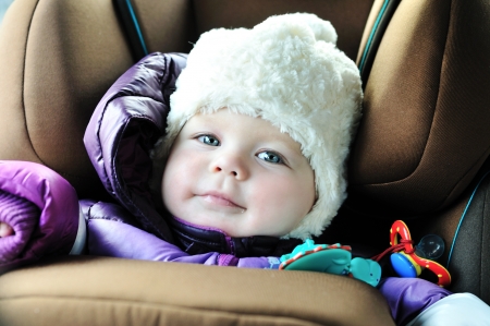 8 months old baby girl in a safety car seat with catch frame systemの写真素材