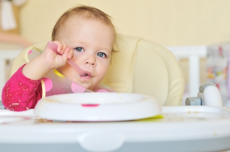 little girl eating cereal on her ownの写真素材