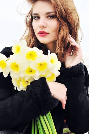 young beautiful teen girl with daffodilsの写真素材