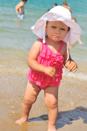 baby girl walking on the beachの写真素材