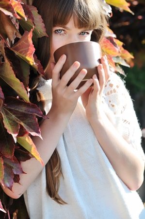 young woman with mug of hot drink outdoorsの写真素材