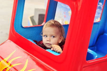 baby girl driving a train  in theme parkの写真素材