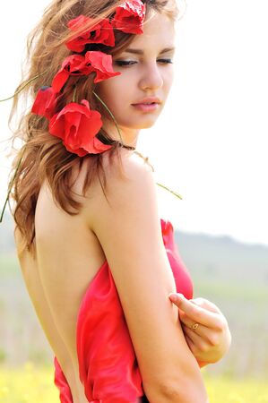 sweet lady standing with poppies in her hairの写真素材