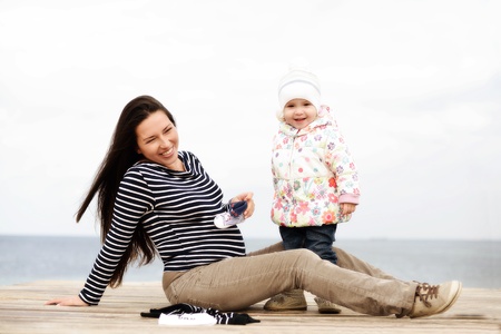 pregnant mother with daughter near the seaの写真素材
