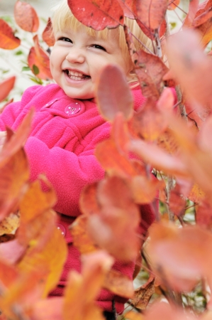 laughing girl standing in bushesの写真素材