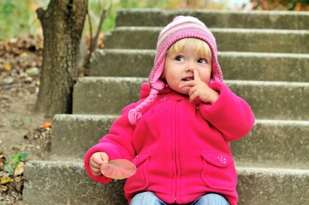 baby girl picking her nose outdoorsの写真素材
