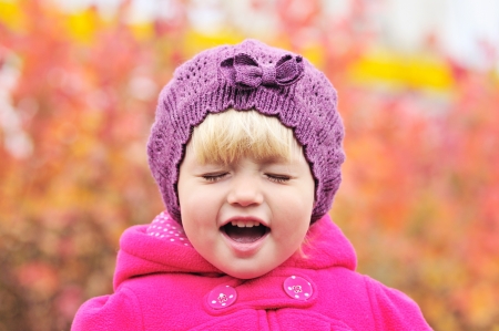 crying toddler girl on over the fall backgroundの写真素材