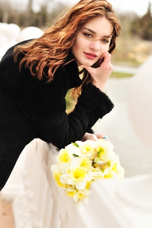 pretty girl with daffodils in windy spring dayの写真素材