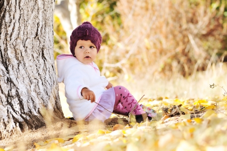 fashion baby girl  sitting under the treeの写真素材