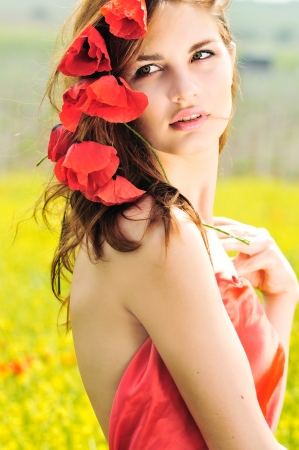 girl standing with poppies in her hairの写真素材
