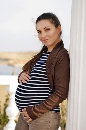 tender pregnant woman near the columnの写真素材