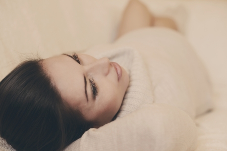 tender pregnant woman lying on the sofaの写真素材