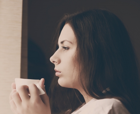 young woman with morning coffee near the windowの写真素材