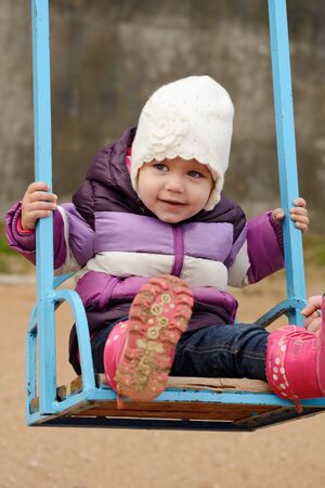 funny toddler girl on swingの写真素材