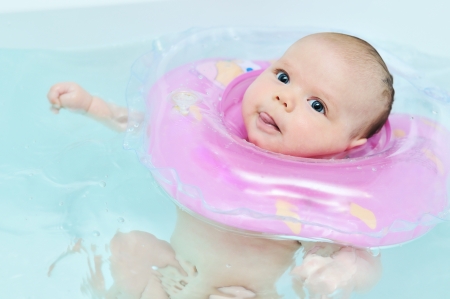 swimming baby in the bath  showing tongueの写真素材