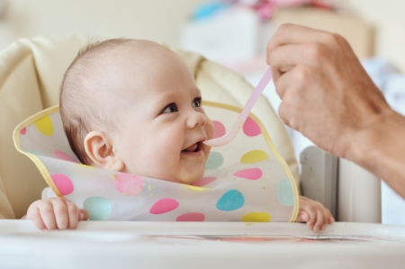 father feeding baby with spoonの写真素材