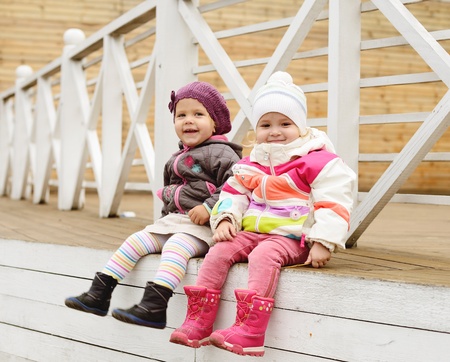 happy toddler girls sitting outdoorsの写真素材