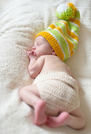 funny sleeping newborn wearing long hatの写真素材