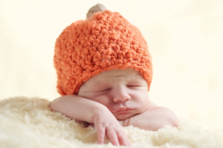 funny newborn wearing pumpkin hatの写真素材