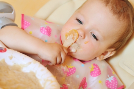 eating baby girl with dirty faceの写真素材
