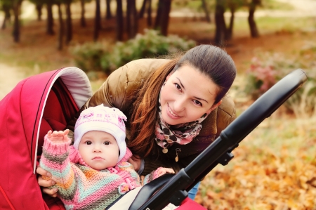 mother walking in the park with her baby in strollerの写真素材
