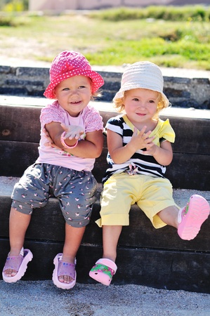 two happy toddler girls having fun outdoorsの写真素材