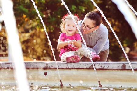 happy mother with baby girl near the fontainの写真素材