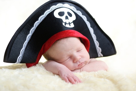 newborn wearing big pirate hatの写真素材