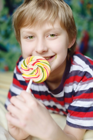 boy eating lollipop at homeの写真素材
