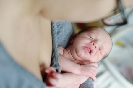 mother holding and calming down her newborn babyの写真素材