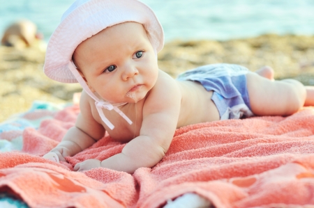 three months old baby on the beachの写真素材