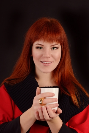 girl with  cup of hot drink over the blackの写真素材