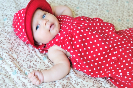 Ñute baby wearing dotted dress and hatの写真素材
