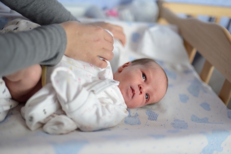 mother  changing clothing of her newborn babyの写真素材