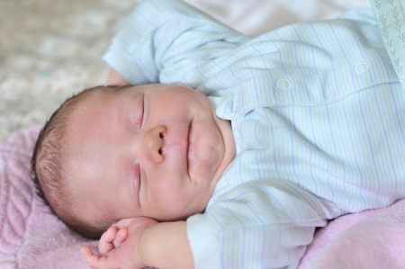 funny newborn 	sluging on the sunny side of bedの写真素材