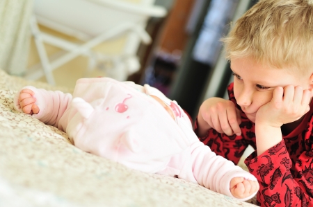 first meeting of little boy and newborn sisterの写真素材