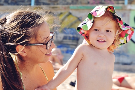baby daughter and her  mother on the beachの写真素材