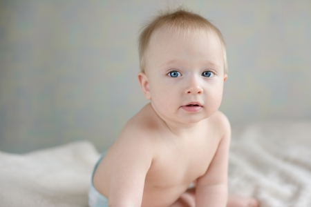 blue-eyed baby sitting on the sofaの写真素材