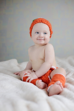 funny baby wearing costume of pumpkinの写真素材
