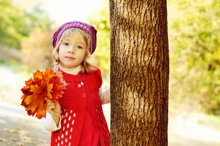 girl in fall with bouquet of leavesの写真素材