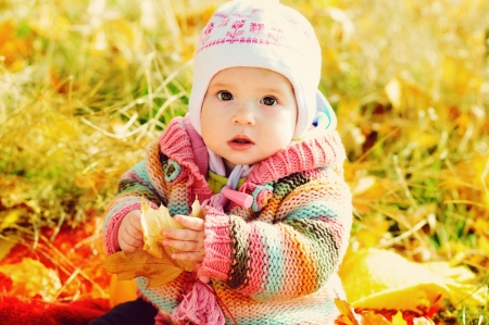 baby girl in fall park with leafの写真素材