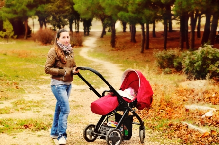 woman with stroller  walking in the fall parkの写真素材