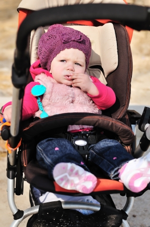 cute fashion girl sitting in strollerの写真素材