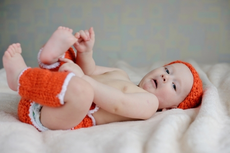 baby is  laying and catching  own legsの写真素材