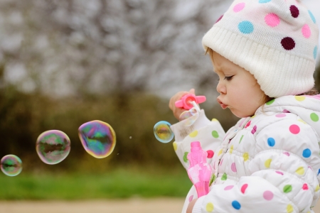 girl with soap bubbles in spring timeの写真素材