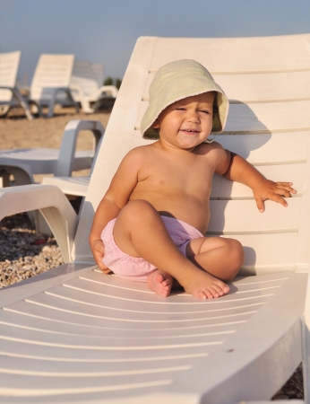 cute baby sitting on  sun lounger の写真素材