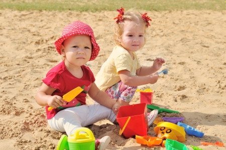 two baby girs playing in sandの写真素材